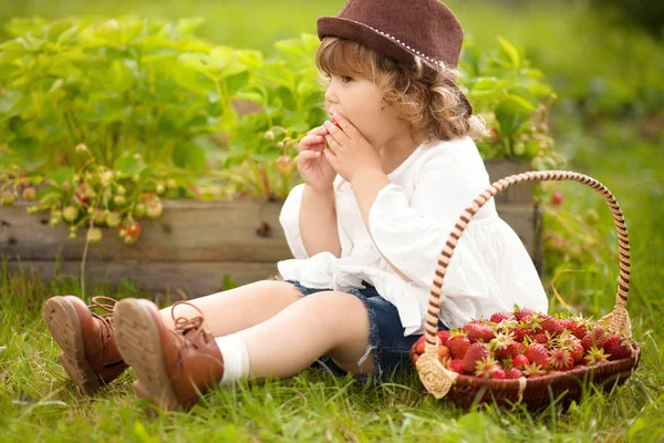 Очаровательная маленькая девочка с корзиной полной клубники — стоковое фото