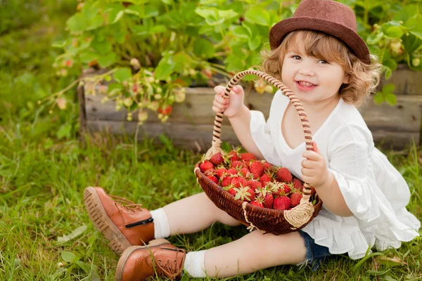 Adorable petite fille avec le panier plein de fraises — Photo