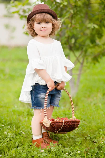 Adorable petite fille avec le panier plein de fraises — Photo