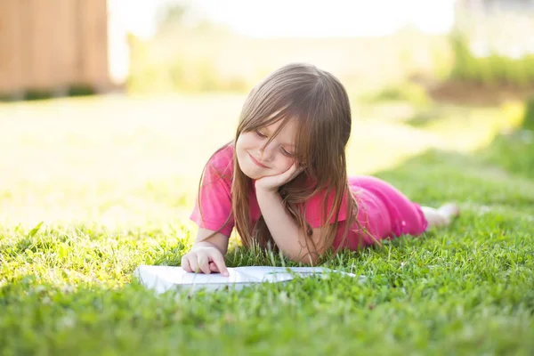 Niña preescolar aprender a leer al aire libre — Foto de Stock