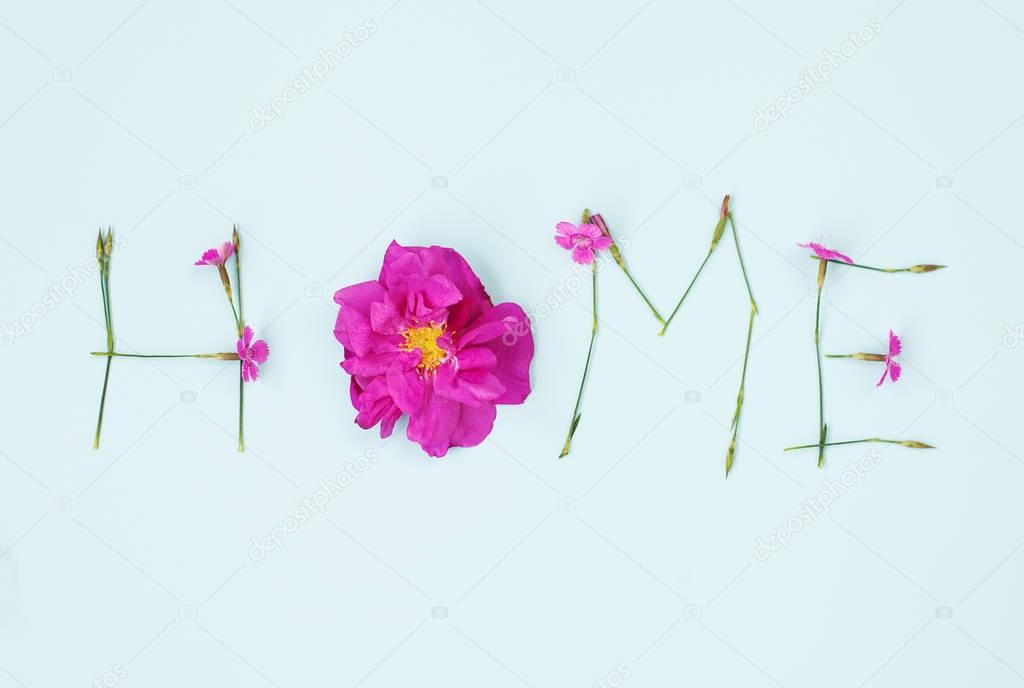 Word HOME written with carnation and wild rose flowers