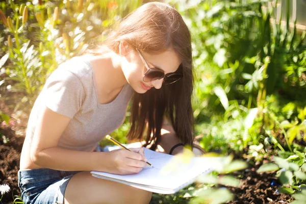 Étudiant fille dessiner des fleurs dans le parc — Photo