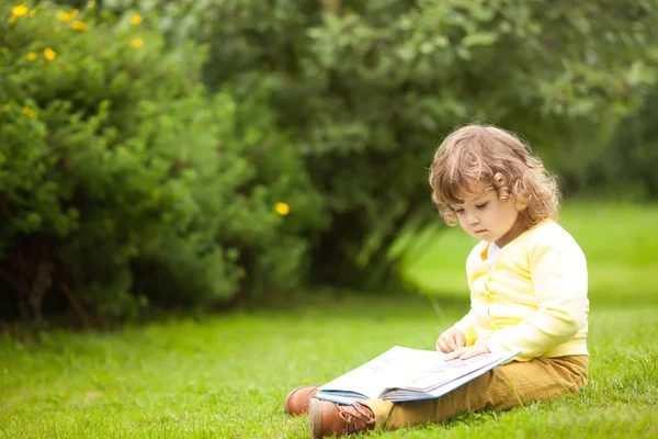 Linda niña leyendo un libro al aire libre — Foto de Stock