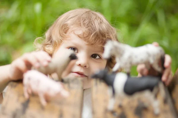 Entzückendes kleines Mädchen spielt mit Tierspielzeug — Stockfoto