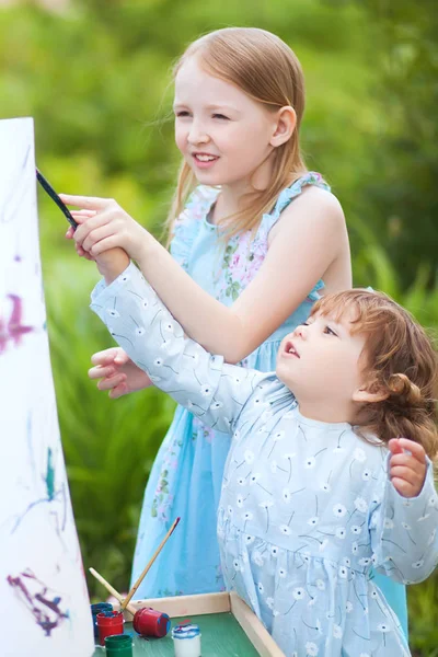 Irmãs pequenas pintando ao ar livre, se divertindo — Fotografia de Stock