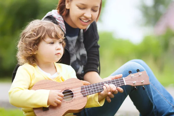 Ukulele gitar çalmayı öğrenmek talanted yürümeye başlayan çocuk kız