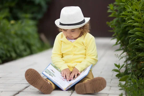 Linda niña leyendo un libro al aire libre — Foto de Stock