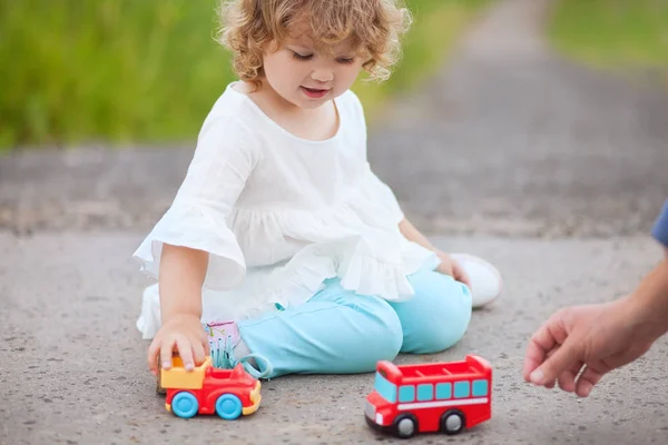 Kleines Mädchen spielt mit ihrem Vater mit Spielzeugautos — Stockfoto