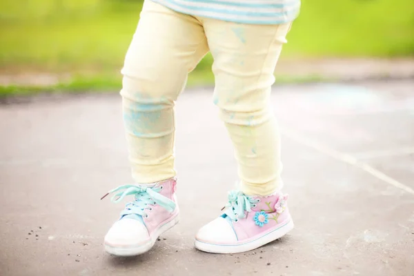 Małe dziewczynki poplamione spodnie po rysunek wirh kolor kreda — Zdjęcie stockowe