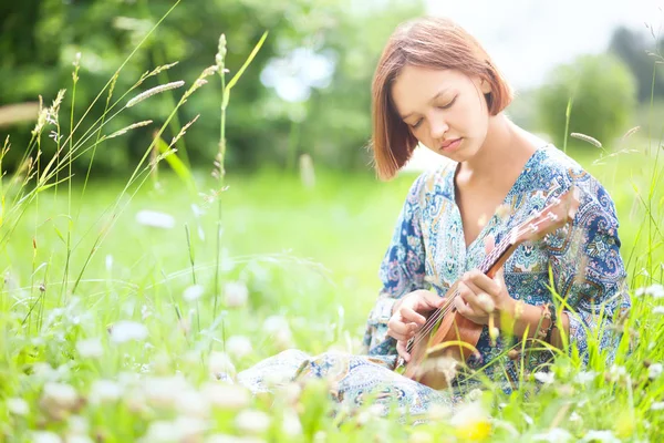Genç kadın ukulele üzerinde oynama