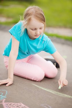 Liseli kız renk tebeşir parçası ile çizim
