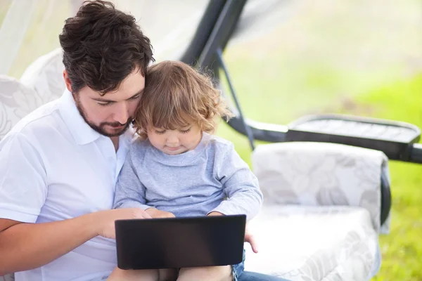 Vater lehrt seine Tochter mit Laptop lizenzfreie Stockbilder