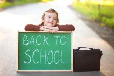 Sevimli küçük kız bir okula otobüs bekleyen