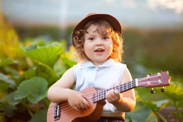 Bambina giocare ukulele all'aperto Foto Stock