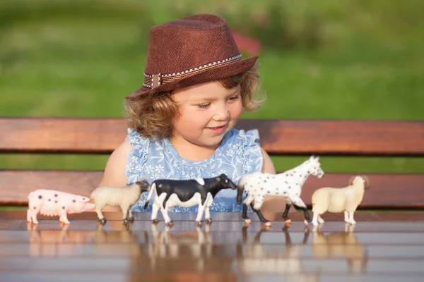 Entzückendes kleines Mädchen spielt mit Tierspielzeug — Stockfoto