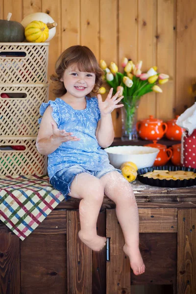 Divertida niña cocinando pastel de manzana en la cocina — Foto de Stock