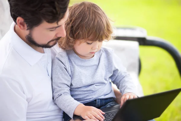 Отец учит свою дочь с помощью ноутбука, ребенка и технологии — стоковое фото