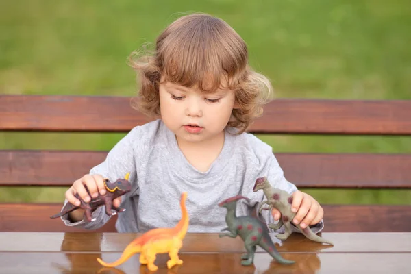 Bambino bambino che gioca con un dinosauro giocattolo Fotografia Stock