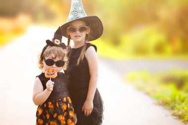 İki küçük kız kardeş Cadılar gibi giyinmiş