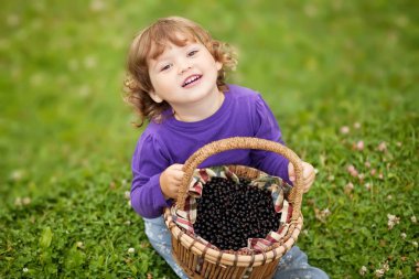 Sepeti dolu Siyah frenk üzümü berry ve mutlu yürümeye başlayan çocuk kız