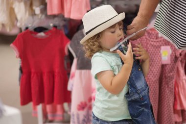 Sevimli küçük kız dükkanda giysiler seçmek