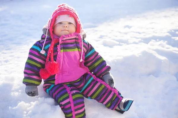 Piccolo bambino seduto su una neve, giorno d'inverno — Foto Stock