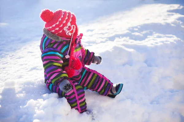 Pequeño bebé sentado en una nieve, día de invierno — Foto de Stock