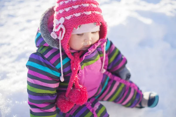 Pequeno bebê sentado em uma neve, dia de inverno — Fotografia de Stock