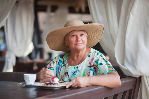 Una donna anziana seduta al ristorante . Foto Stock Royalty Free