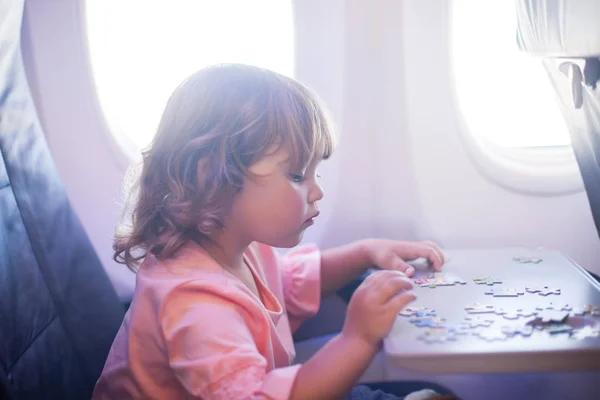 Adorável menina viajando de avião . Imagens Royalty-Free