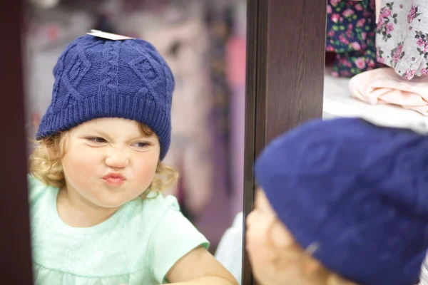 Roztomilá holčička výběr oblečení v obchodě — Stock fotografie