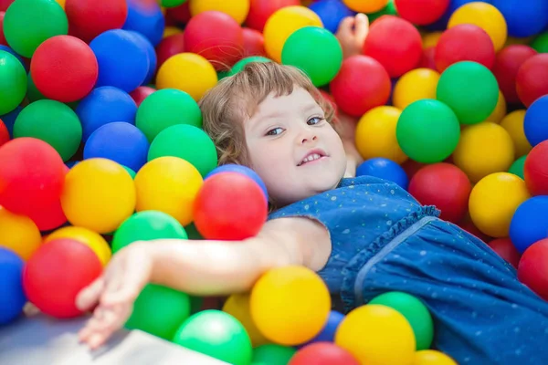 Criança menina feliz na piscina bolas plásticas coloridas . — Fotografia de Stock