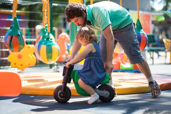 Kleines Mädchen spielt mit ihrem Vater auf einem Spielplatz. — Stockfoto