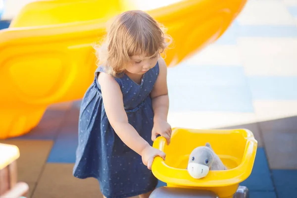 Kleines Kind auf dem Spielplatz, Jungen Spielzeug für Mädchen. — Stockfoto