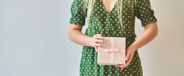 Bir kız beyaz arka planda bir hediye kutusu tutuyor. Banner, boşluğu kopyala