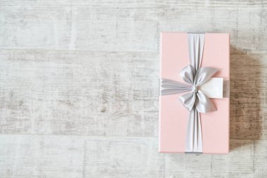 Ahşap bir arka planı olan pembe hediye kutusu..