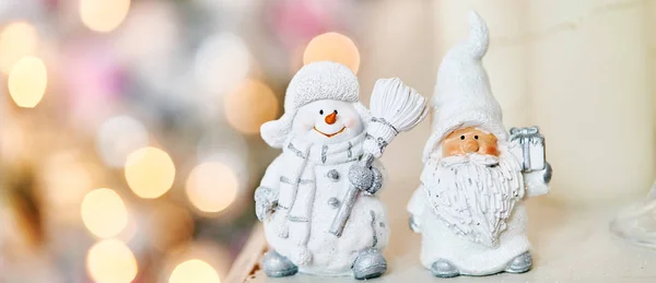 Muñeco de nieve de juguete y Santa Claus en el fondo de un árbol de Navidad y guirnaldas . — Foto de Stock