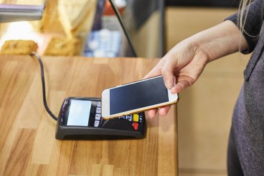 Kahve dükkanındaki ödeme terminalinde kredi kartıyla ödeme emrini kapat.