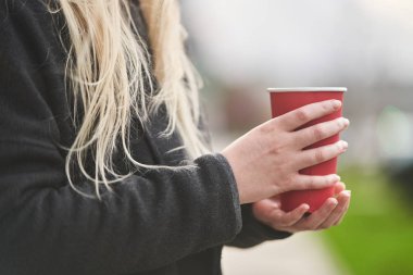 Genç bir kız elinde kahveyle bir fincan tutuyor.. 