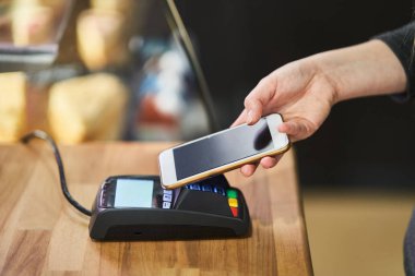 Kahve dükkanındaki ödeme terminalinde kredi kartıyla ödeme emrini kapat.