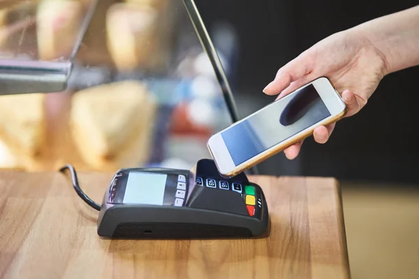 Afsluiten hand betalen bestelling met creditcard op betaalterminal in de coffeeshop — Stockfoto