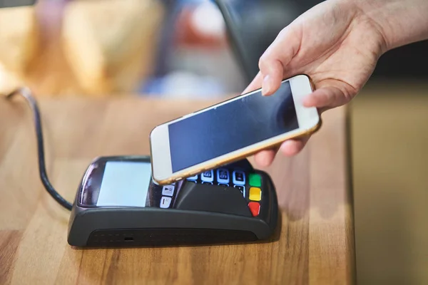 Fermer la main payer l'ordre par carte de crédit sur le terminal de paiement dans le café — Photo