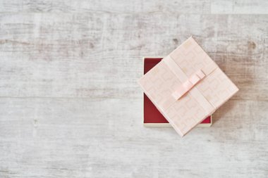 Ahşap bir arka planı olan pembe hediye kutusu..