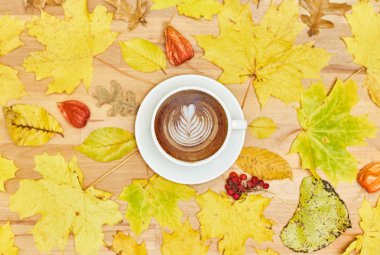 Sonbahar düz kompozisyonu kuru yapraklı çelenk çerçevesi ve ahşap zemin üzerinde kahve fincanı.. 