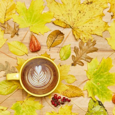 Sonbahar düz kompozisyonu kuru yapraklı çelenk çerçevesi ve ahşap zemin üzerinde kahve fincanı.. 