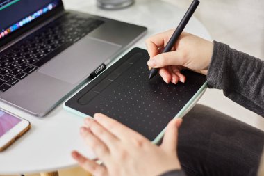 Kaliningrad, Rusya - 27 Ekim 2019: Genç bir kız grafik tabletine resim çiziyor. Freelancer bir kafede çalışıyor.