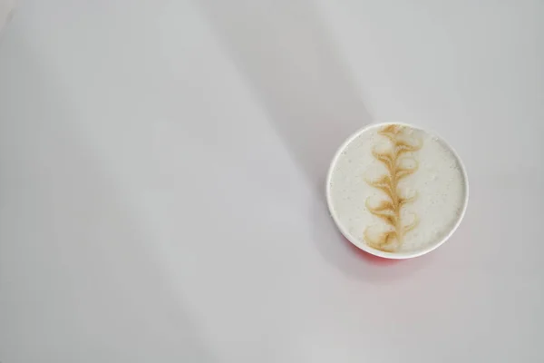 red paper cup with coffee in a coffee shop