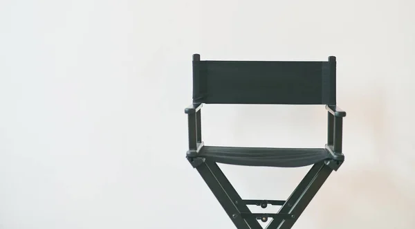 黑人导演的椅子靠着白墙 — 图库照片