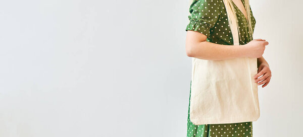 A Girl is holding blank cotton eco tote bag, design mockup.