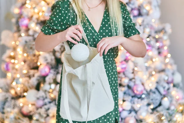 Una mujer joven saca una pelota de una bolsa . —  Fotos de Stock